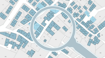 Imaginary cadastral map with buildings, land parcel and vacant plot - property registry and real estate concept seen through a magnifying glass
